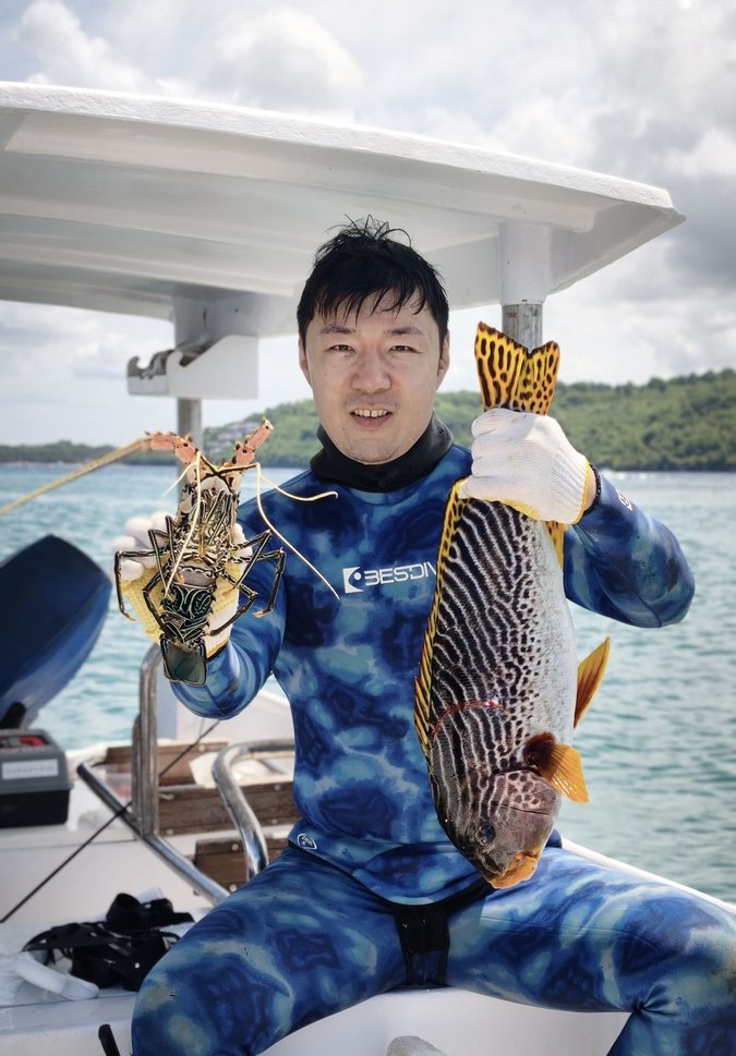 Guest holding lobster and fish on the Jackpot